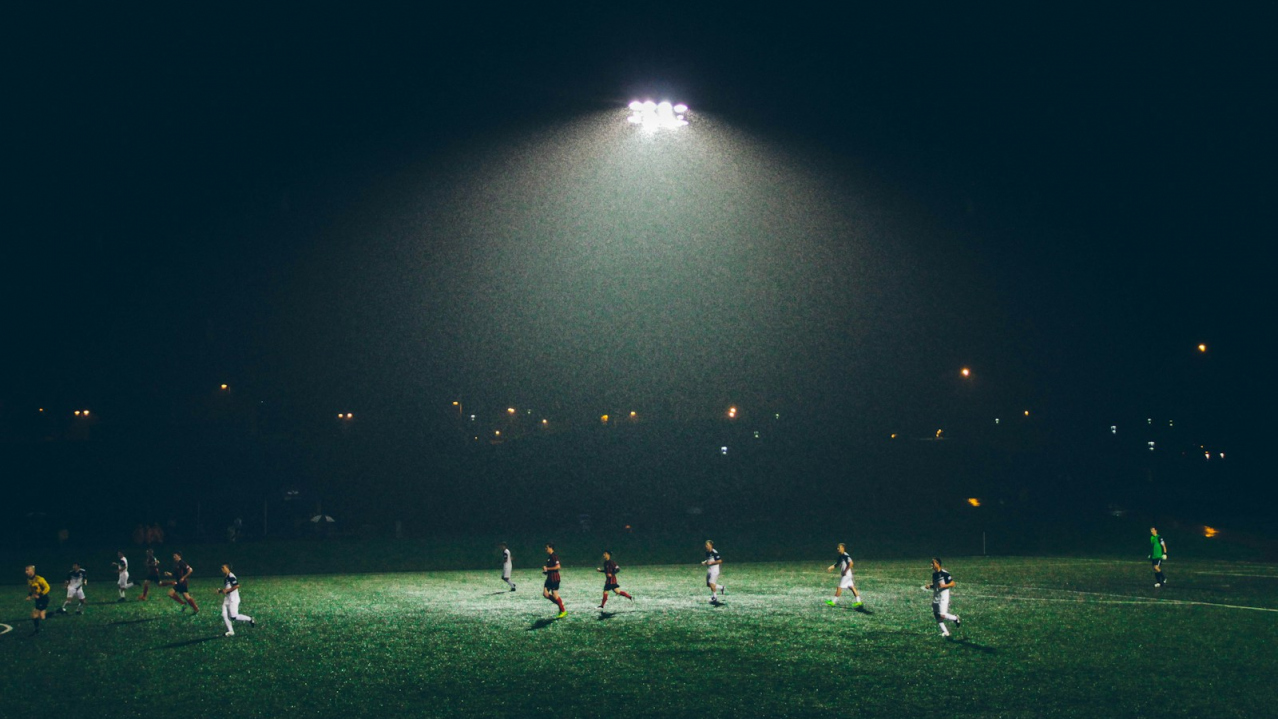 group of people playing soccer on soccer field